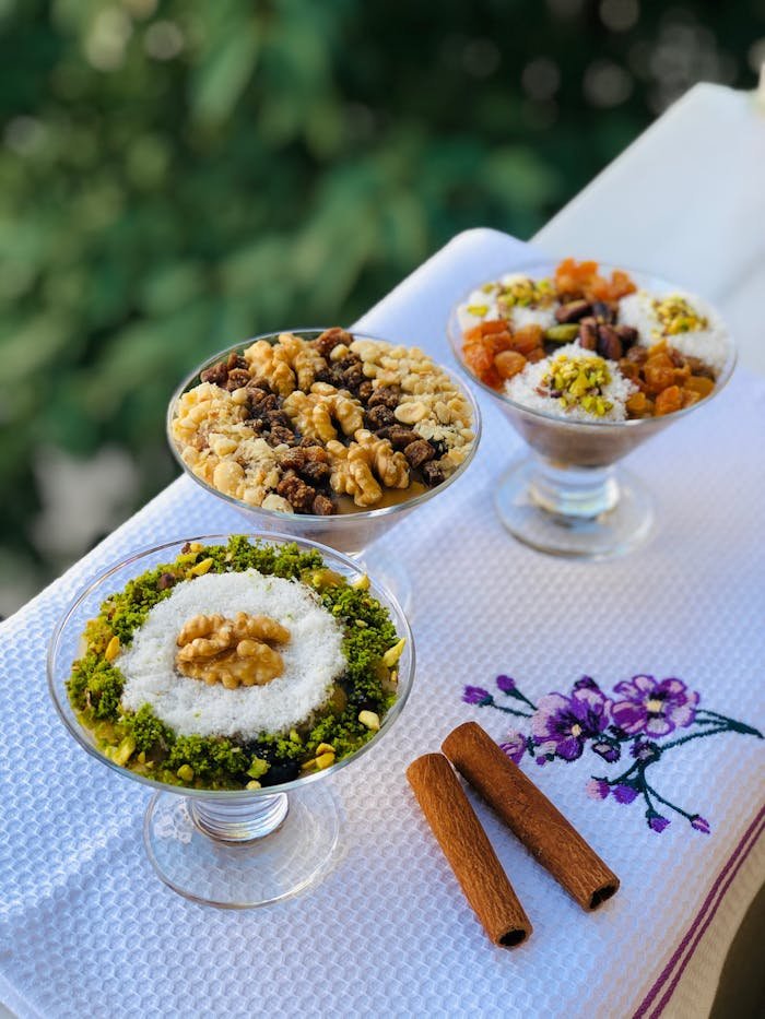 Close-up of three dessert bowls with nuts and pistachios, perfect for a sweet treat.